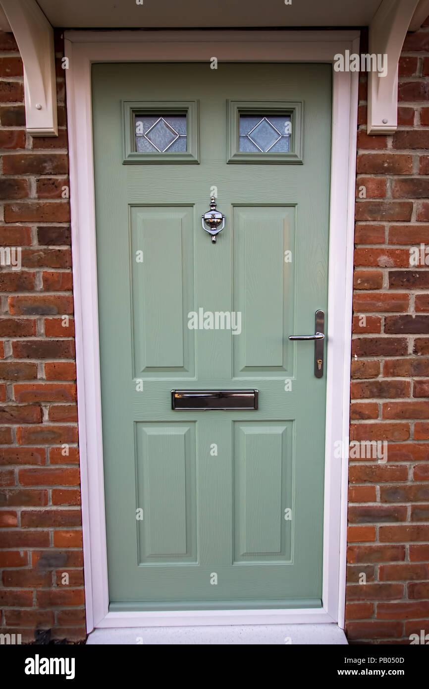 Green door. Modern house composite upvc front door with chrome hardware. Timber look classic design. Stock Photo