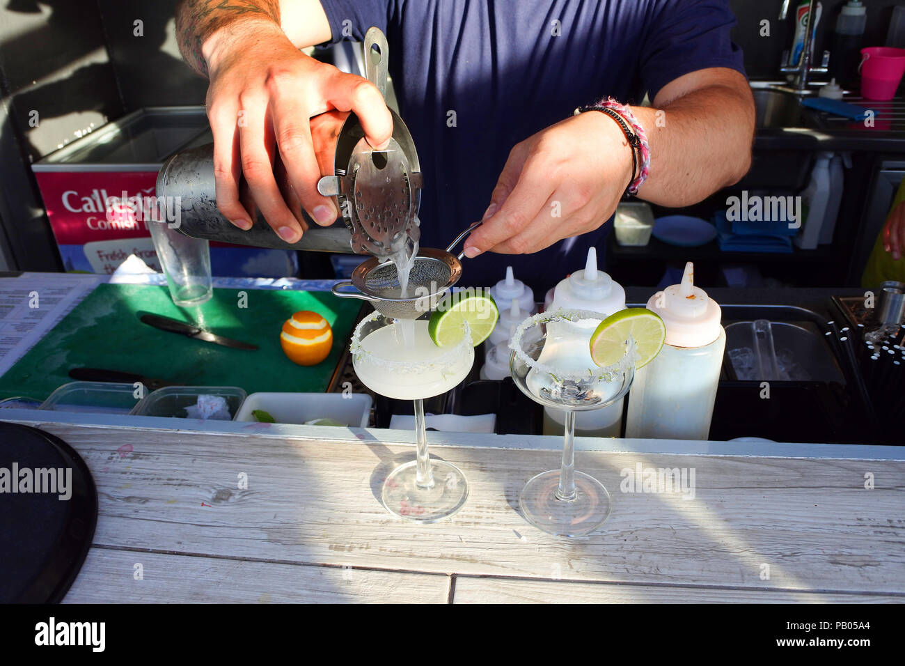 Close-up of a pair of hands serving a cocktail - John Gollop Stock Photo