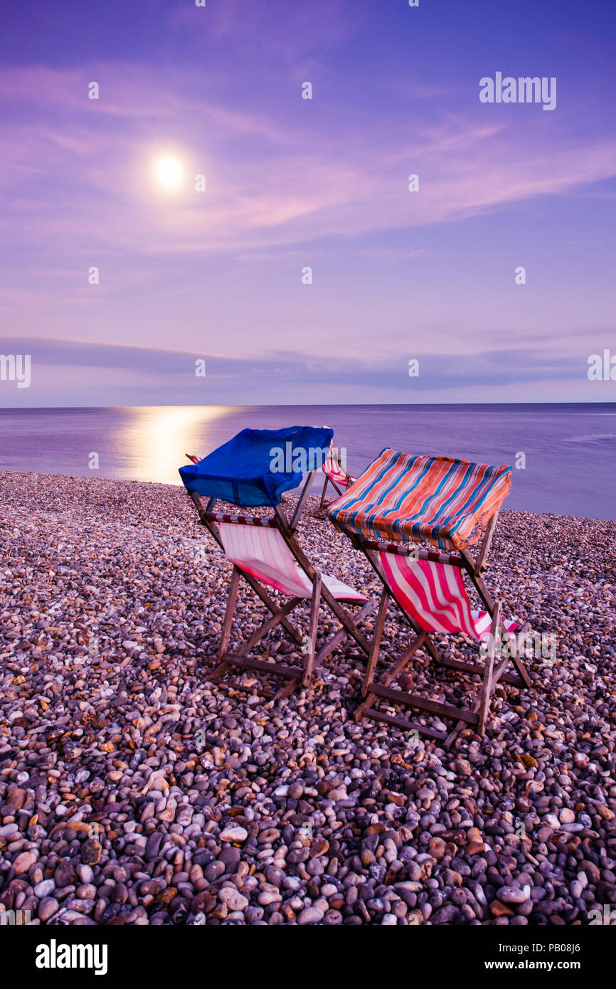 Deck chairs on the beach by moonlight Stock Photo - Alamy