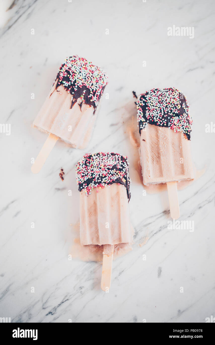 Three yogurt icecreams dipped in chocolate and sprinkles Stock Photo