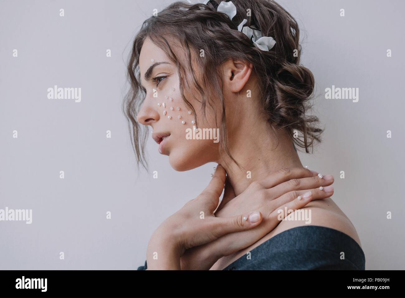 Portrait of a woman with pearls on her face and fingers Stock Photo