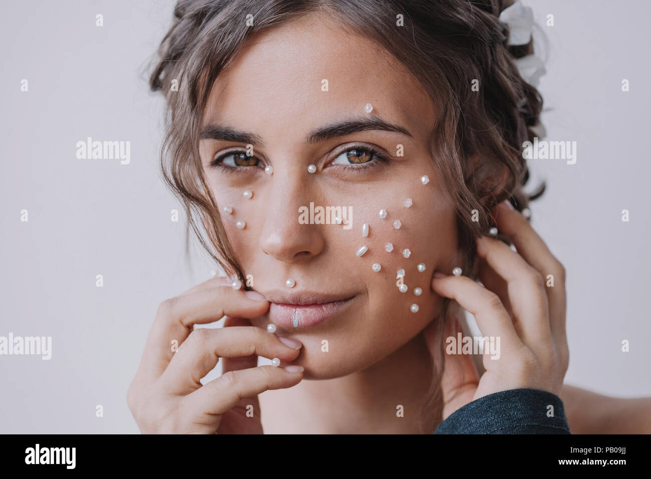 Portrait of a woman with pearls on her face and fingers Stock Photo