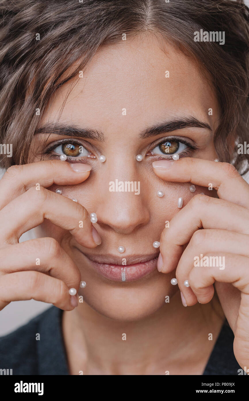 Smiling woman with pearls on her face Stock Photo