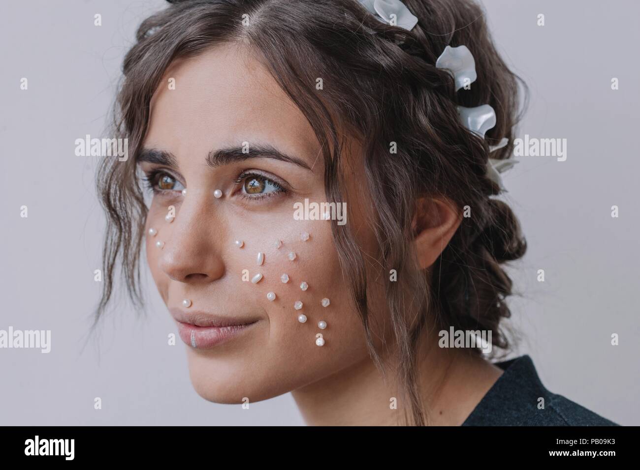 Portrait of a smiling woman with pearls on her face Stock Photo
