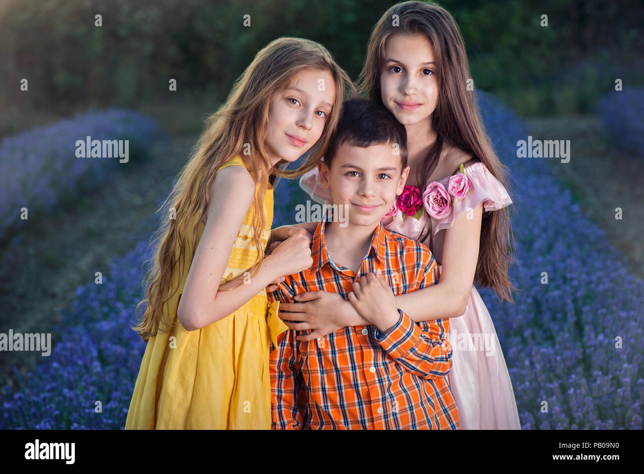 Three smiling children standing in a lavender field, Shipka, Stara Zagora, Bulgaria Stock Photo