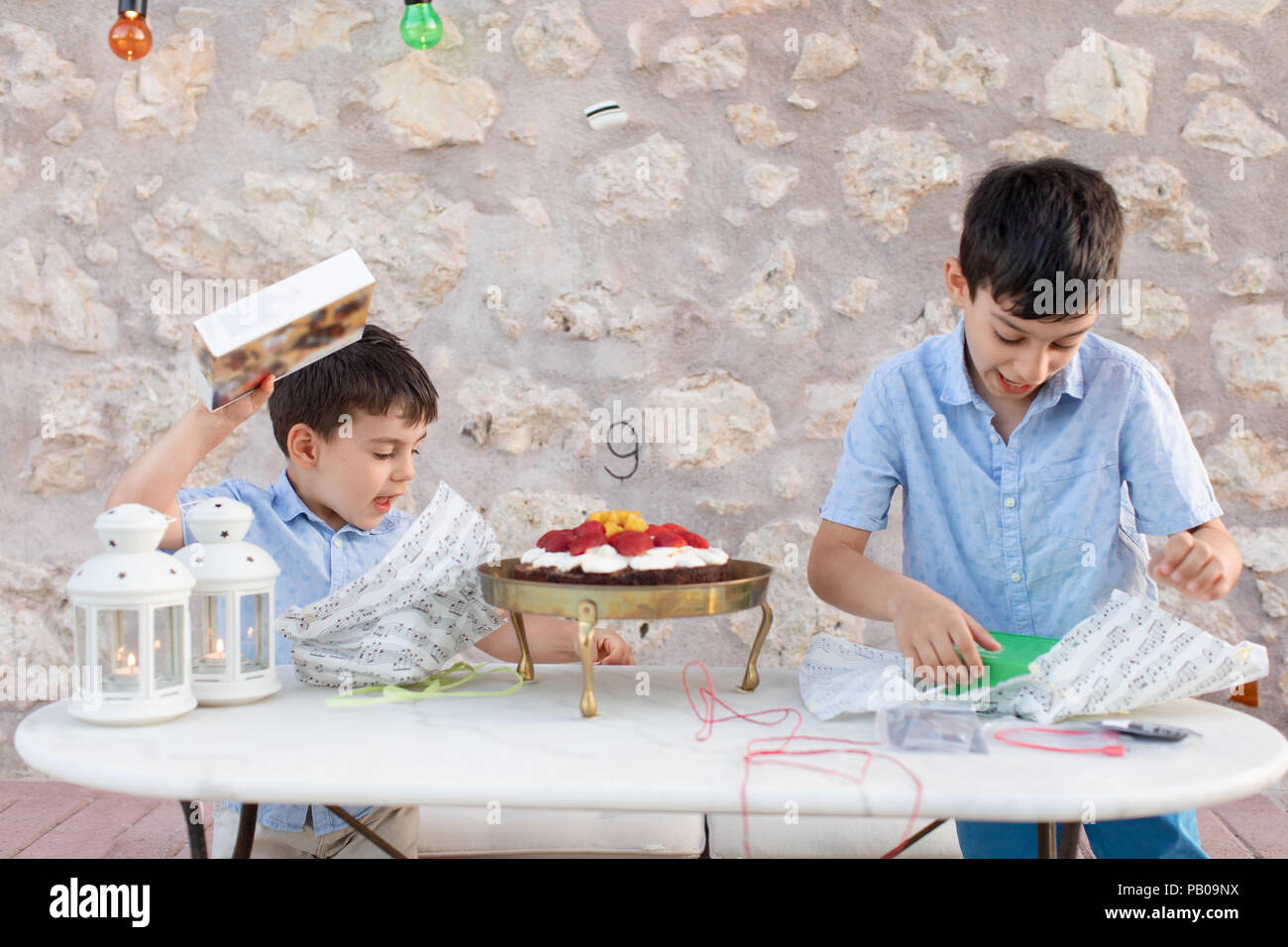 Two boys unwrapping birthday presents Stock Photo