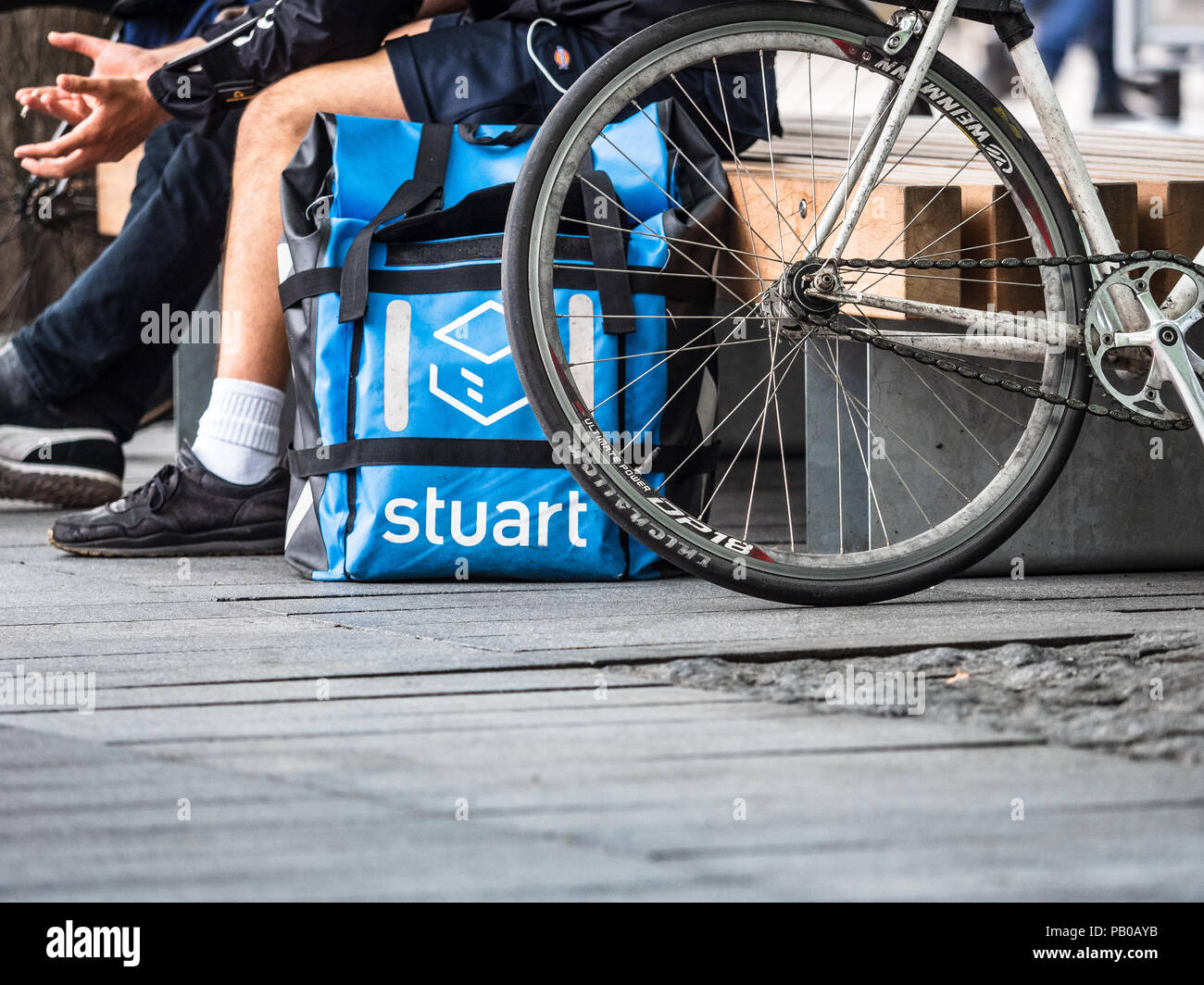 Stuart Delivery Couriers take a break between client deliveries. The company was founded in 2015 and operates in 15 cities. Stock Photo