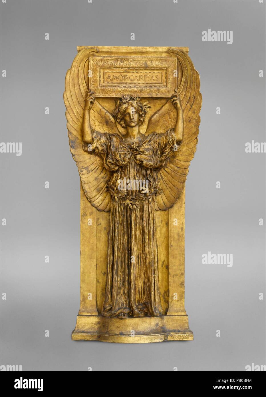 Amor Caritas. Artist: Augustus Saint-Gaudens (American, Dublin 1848-1907 Cornish, New Hampshire). Dimensions: 103 1/4 x 50 in. (262.3 x 127 cm). Date: 1880-98, cast 1918.  'Amor Caritas' represents the perfection of Saint-Gaudens's vision of the ethereal female, a subject that he modeled repeatedly, beginning in 1880. The elegant figure in a frontal pose with free-flowing draperies and downcast eyes also appears in the caryatids for the Vanderbilt mantelpiece (25.234) and in several funerary works. Here, Saint-Gaudens made subtle changes in the drapery and added upward-curving wings, a tablet, Stock Photo