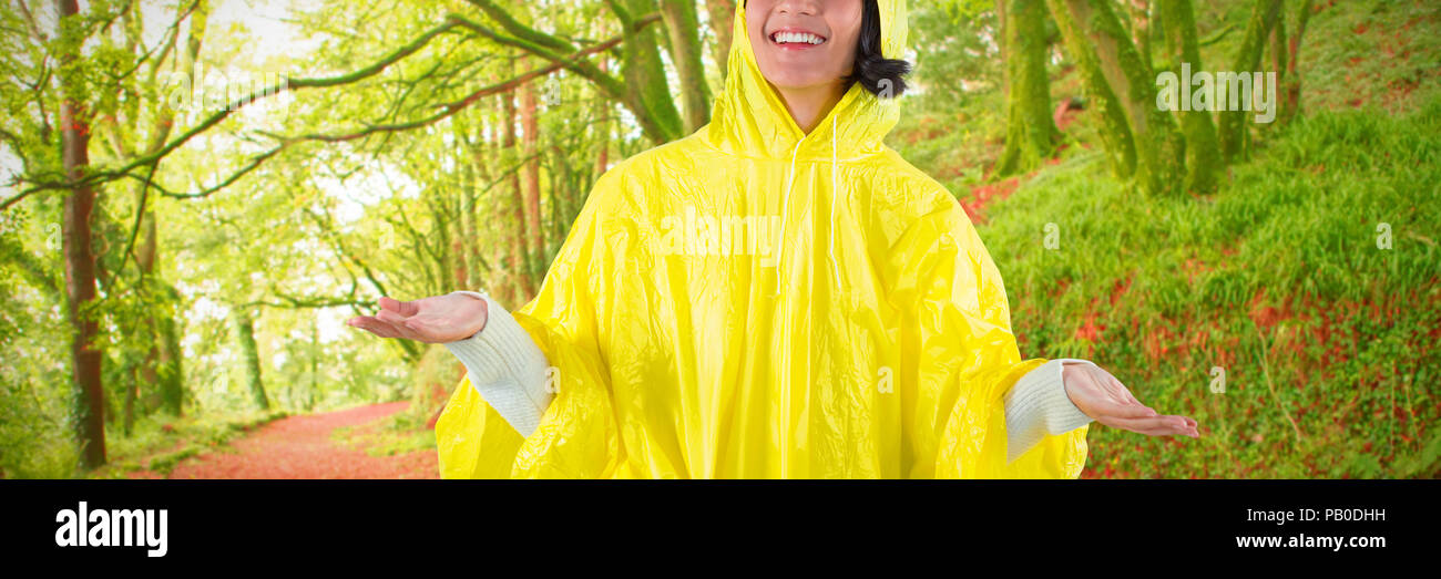 Composite image of woman in yellow raincoat gesturing to feel the rain Stock Photo