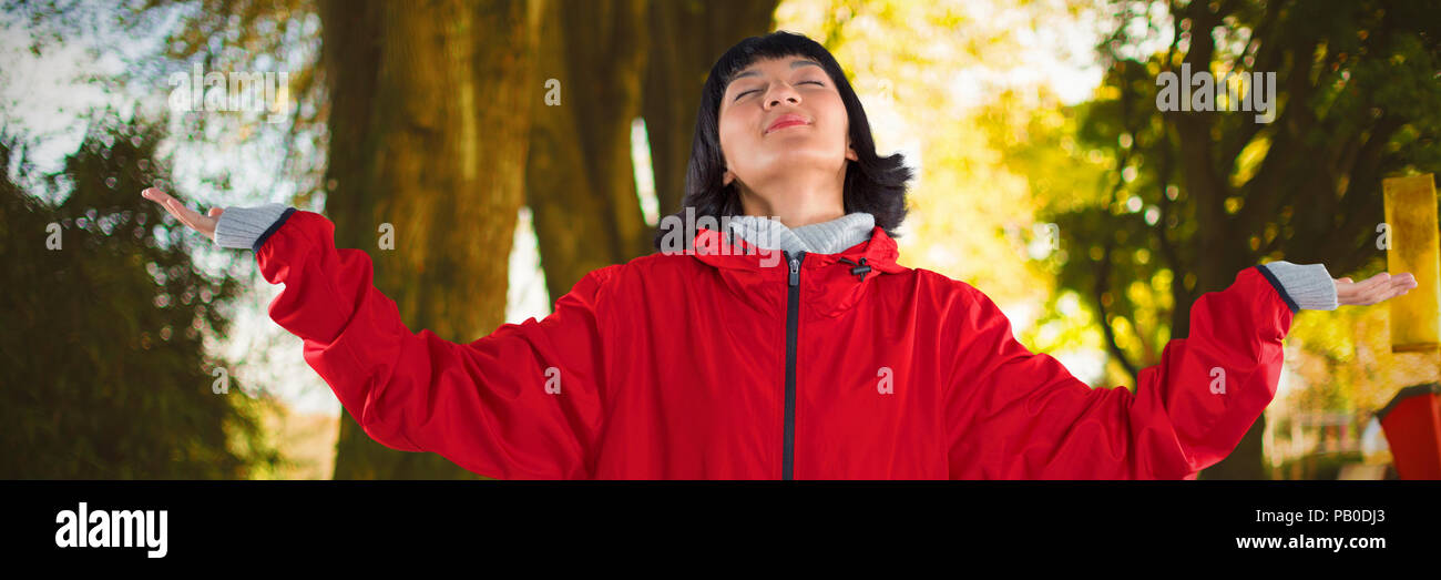 Composite image of blissful woman standing with arms outstretched Stock Photo