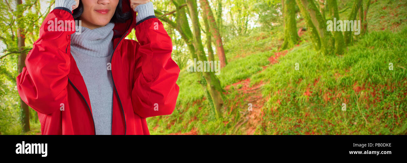 Composite image of woman in hooded jacket standing against white background Stock Photo