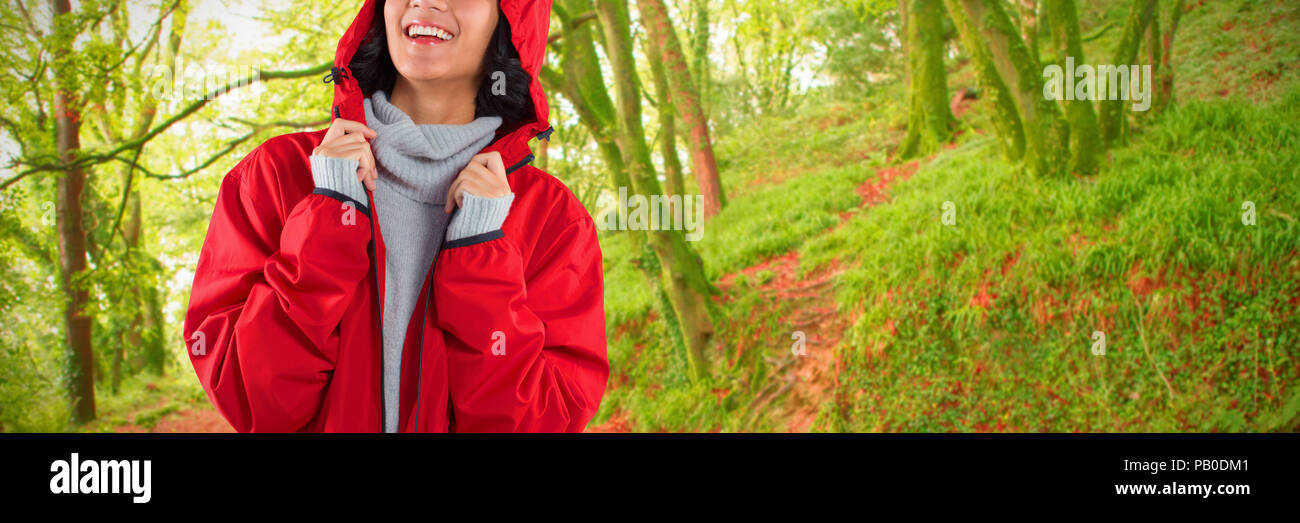 Composite image of woman in hooded jacket standing against white background Stock Photo