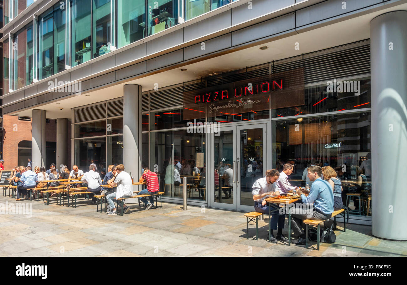 Customers sitting both outside and inside the Pizza Union Pizza restaurant on a hot summer day in Spitalfield, London, England, UK Stock Photo