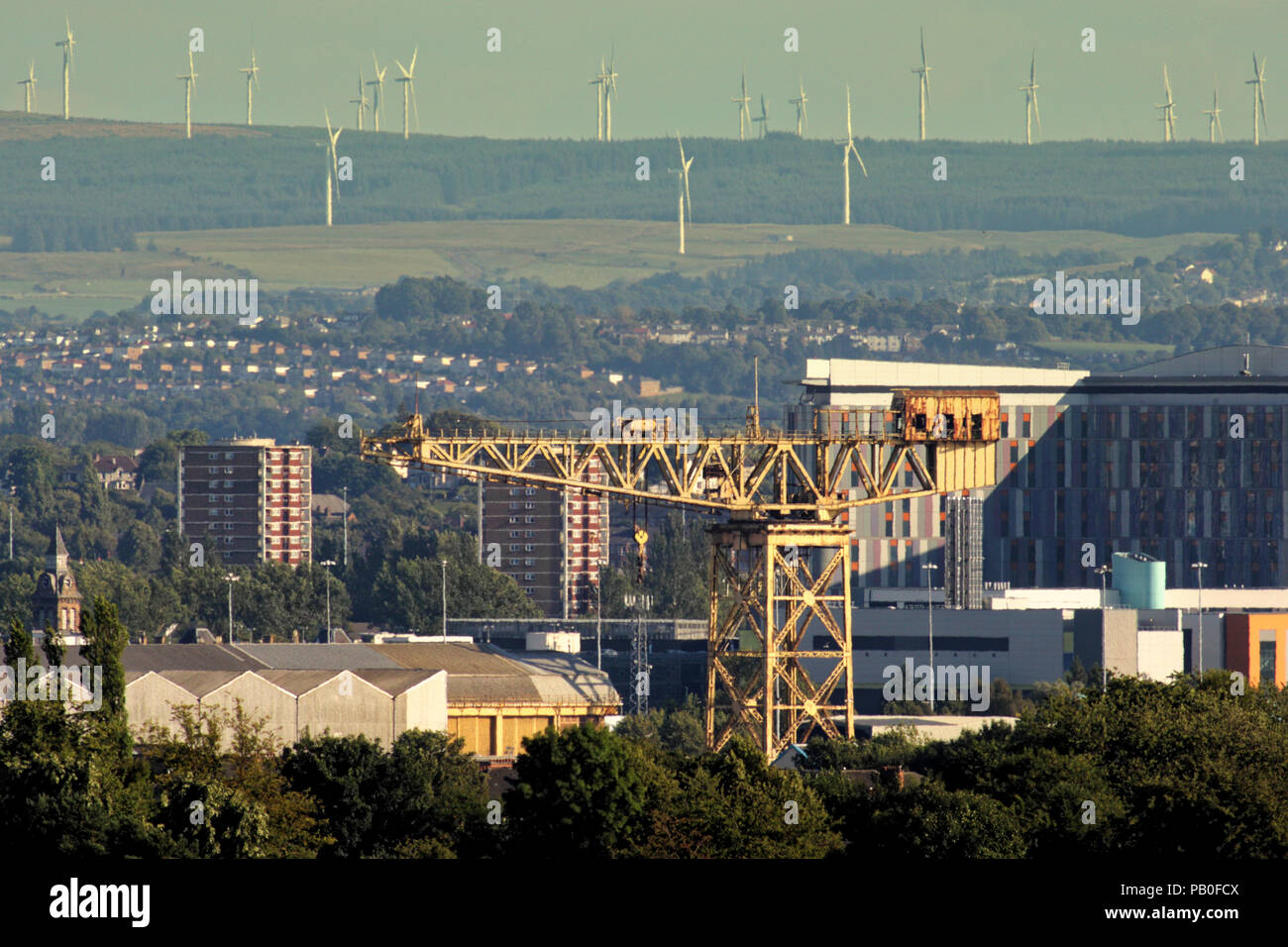 old clyde titan crane  The Barclay Curle Crane near Govan with the modern wind turbines of Whitelee Wind Farm 8 miles away contrasting the old new Stock Photo