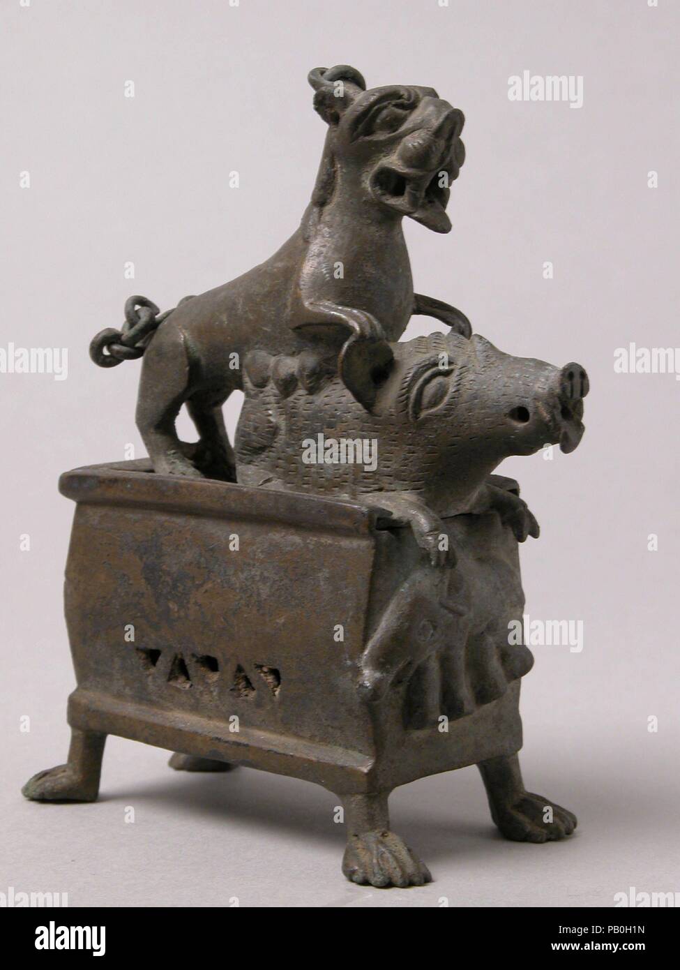 Censer with a Lioness Hunting a Boar. Culture: Coptic. Dimensions: Overall: 5 3/16 x 4 1/8 x 2 1/16 in. (13.2 x 10.4 x 5.3 cm)  Overall (with chain suspended): 8 13/16 x 4 1/8 x 2 1/16 in. (22.4 x 10.4 x 5.3 cm). Date: 6th-7th century.  Discovered hidden in a rock crevice, this censer was cast so that the smoke of the incense would emerge through the mouths and ears of the lioness and boar. An elephant worked in relief, rather than a Christian symbol, appears on its front. Museum: Metropolitan Museum of Art, New York, USA. Stock Photo