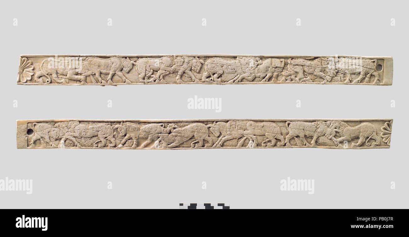 Furniture plaques carved in relief with animal combat. Culture: Assyrian. Dimensions: H. 1 3/4 x W. 21 3/4in. (4.4 x 55.2cm). Date: ca. 8th century B.C..  These long ivory strips were found in a storage room in Fort Shalmaneser, a royal building at Nimrud that was used to store booty and tribute collected by the Assyrians while on military campaign. Since the wooden frame to which the ivory panels were attached had disintegrated, it was not possible to fully reconstruct the piece of furniture to which they belonged. They were probably part of a bed or couch, judging from the large panel associ Stock Photo