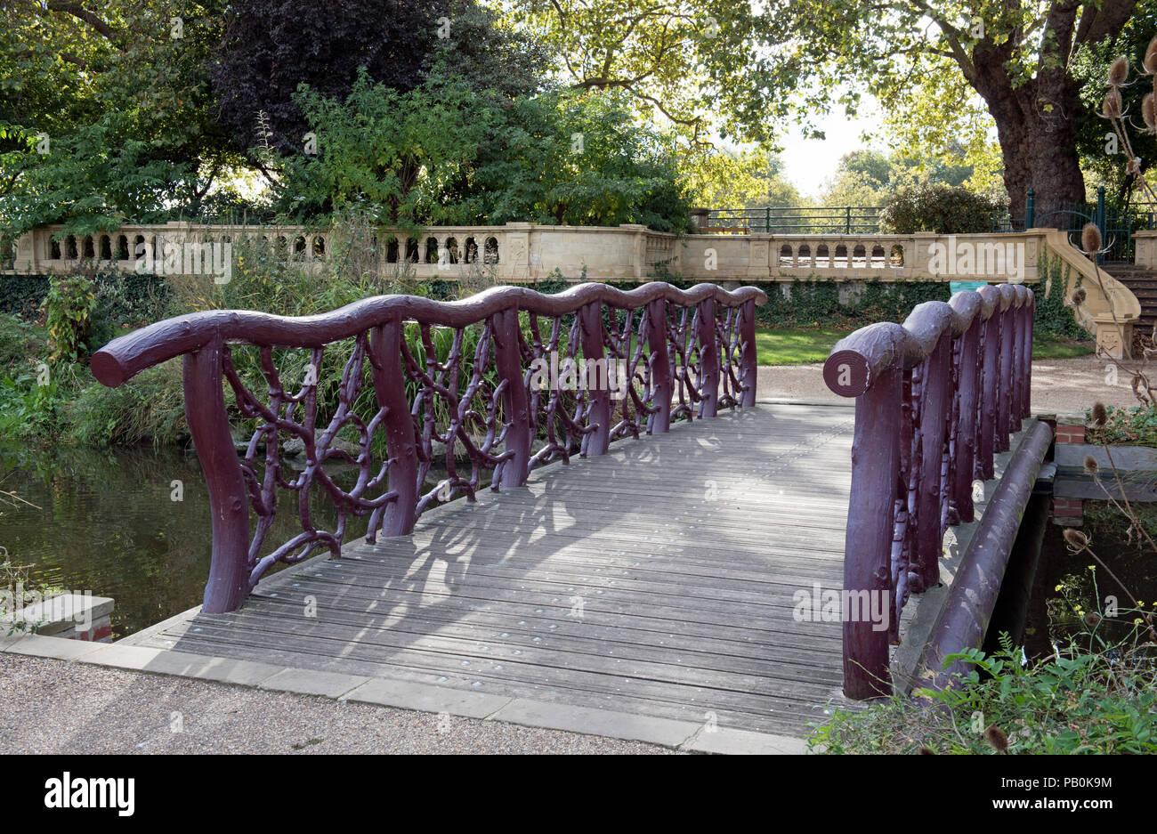 Wooden bridge, parapet made from tree branches, Bishops Park, Fulham London England Britain UK Stock Photo