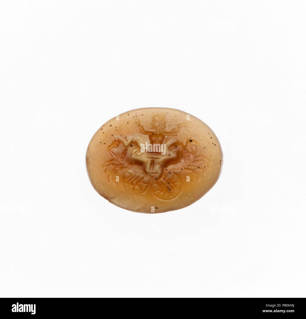 Yellow chalcedony ring stone. Culture: Roman. Dimensions: Length: 9/16 in. (1.5 cm). Date: 1st century B.C.-3rd century A.D..  Helios on a quadriga (four-horse chariot). Museum: Metropolitan Museum of Art, New York, USA. Stock Photo