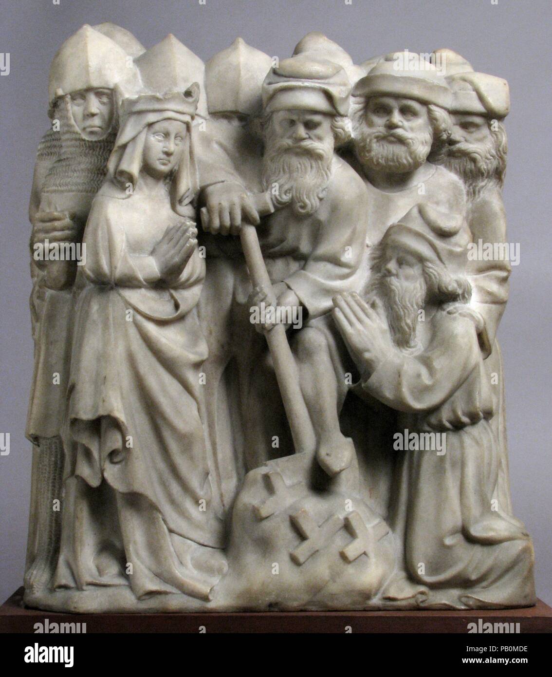 Relief with Scene from the Legend of the True Cross. Culture: South Netherlandish. Dimensions: 15 13/16 × 13 11/16 × 4 15/16 in. (40.1 × 34.7 × 12.5 cm). Date: ca. 1400.  This relief, along with another in the collection (acc. no. 23.79.1), once formed part of a narrative that stretched across the back of an altar. Carved from single blocks of marble, the two compositions feature episodes from the discovery of the True Cross by Saint Helena, the mother of the Roman Emperor Constantine. In order to bring these distant events into the present, the sculptor employed clothing and character types f Stock Photo