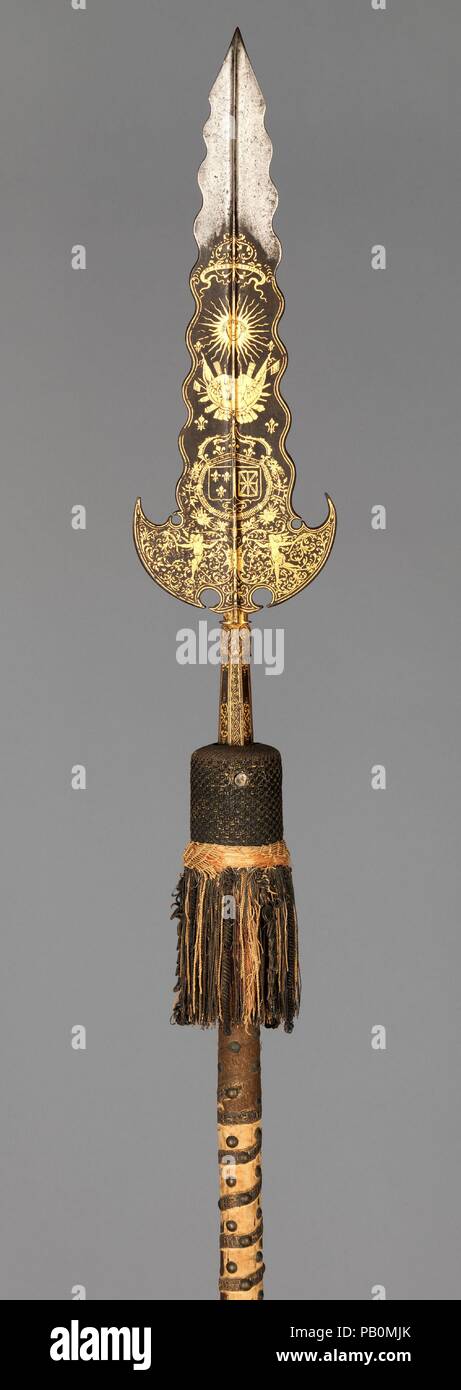 Partisan Carried by the Bodyguard of Louis XIV (1638-1715, reigned from 1643). Culture: French, Paris. Dimensions: L. 94 3/8 in. (239.7 cm); L. of head: 20 3/4 in. (52.7 cm); W. of head 5 7/8 in. (15 cm);. Date: ca. 1658-1715.  This partisan, along with two like it also in the Metropolitan Museum's collection (acc. nos. 14.25.454, 04.3.65), are thought to have been carried by the Gardes de la Manche (literally, 'guards of the sleeve,' indicating their close proximity to the king), an elite unit of the bodyguard of Louis XIV. This example (along with 04.3.65) bears the king's motto and sunburst Stock Photo