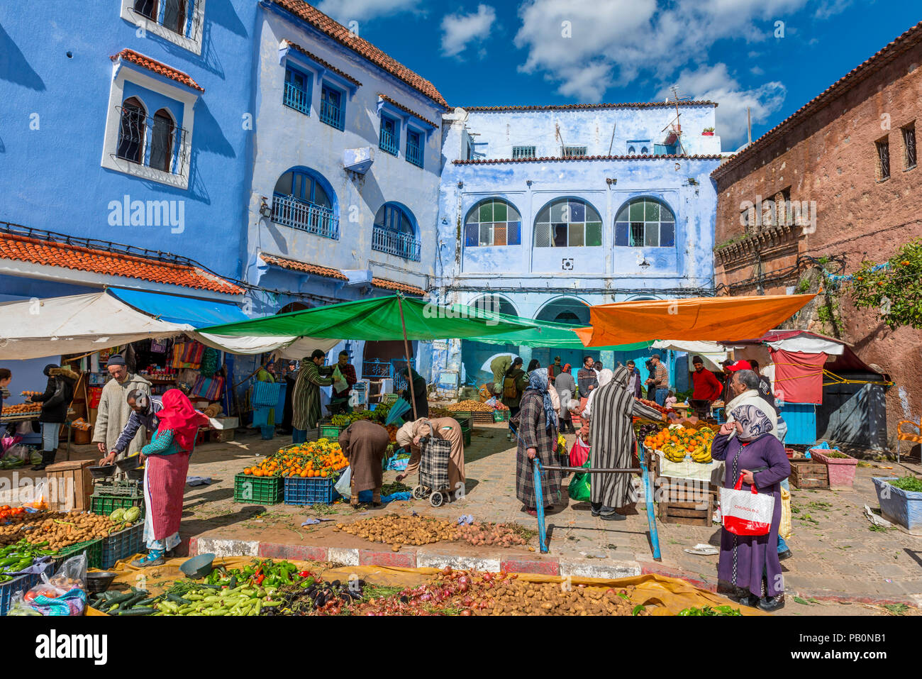 Locals buying vegetables, market in front of Blue Houses, Chefchaouen, Chaouen, Tangier-Tétouan, Kingdom of Morocco Stock Photo