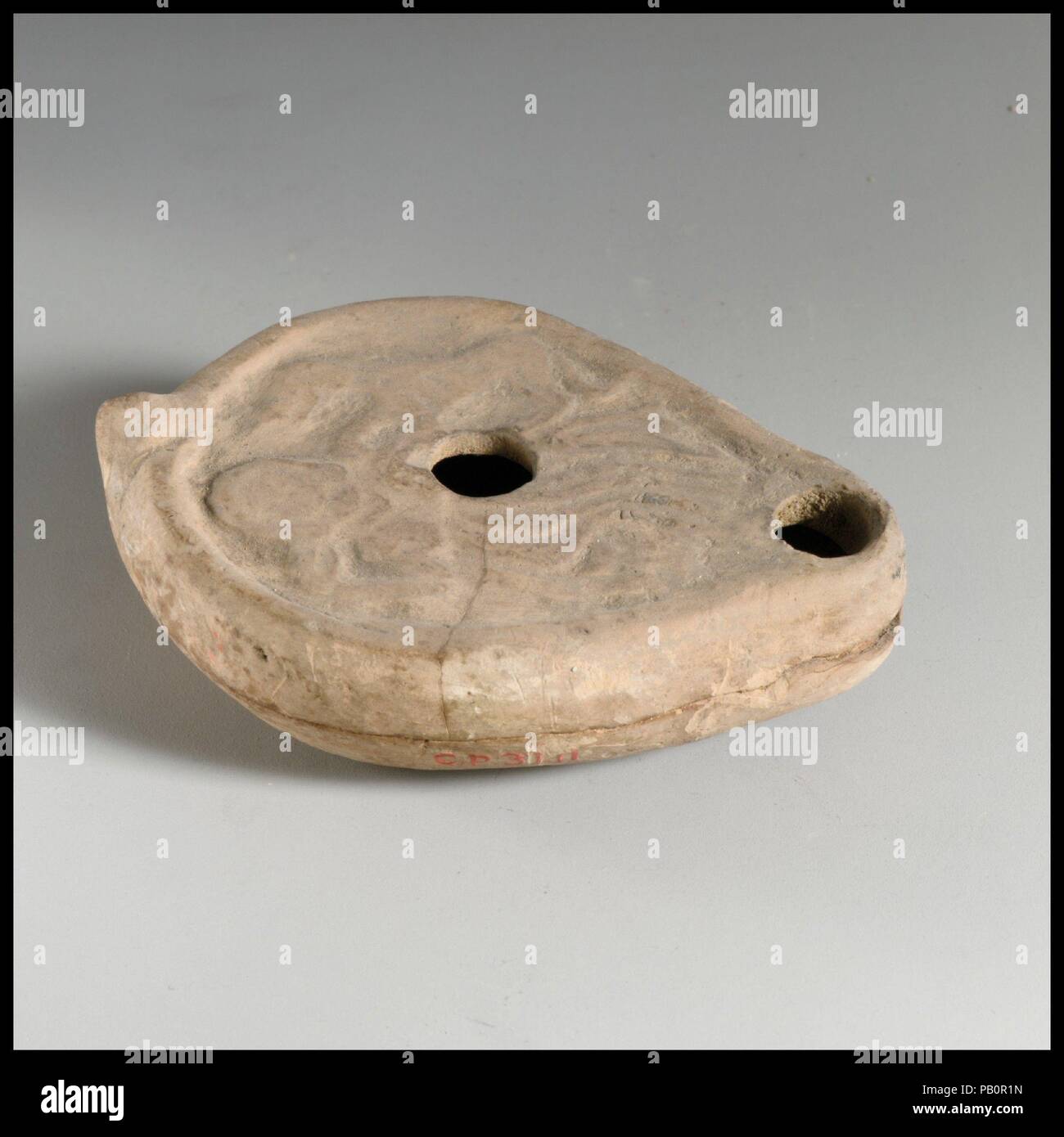 Terracotta oil lamp. Culture: Roman. Dimensions: Overall: 1 x 3 1/4 in. (2.5 x 8.3 cm). Date: 3rd century A.D.. Museum: Metropolitan Museum of Art, New York, USA. Stock Photo