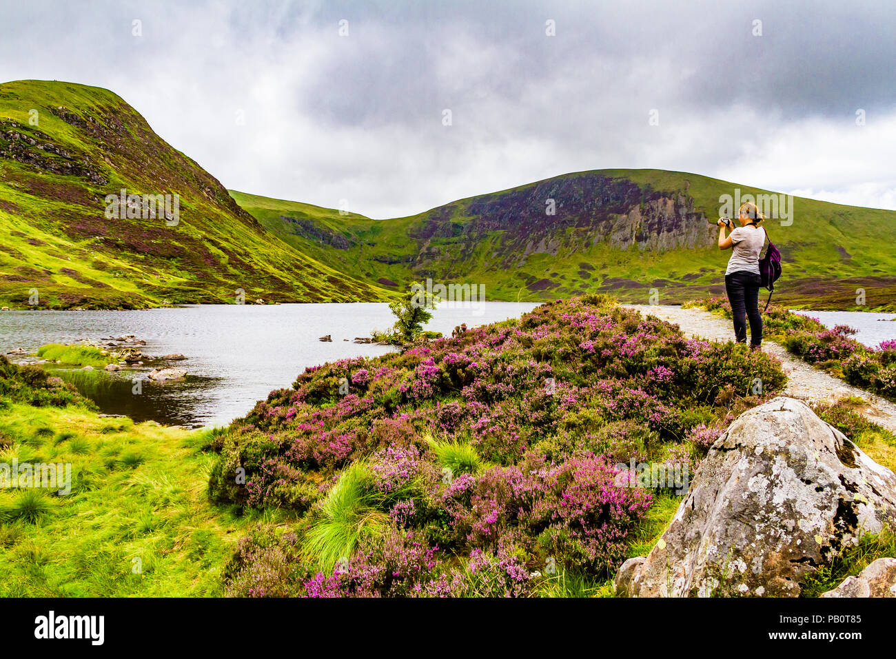 A female photographer takes a picture of Loch Skeen in Dumfries and Galloway, Scotland, UK. Stock Photo
