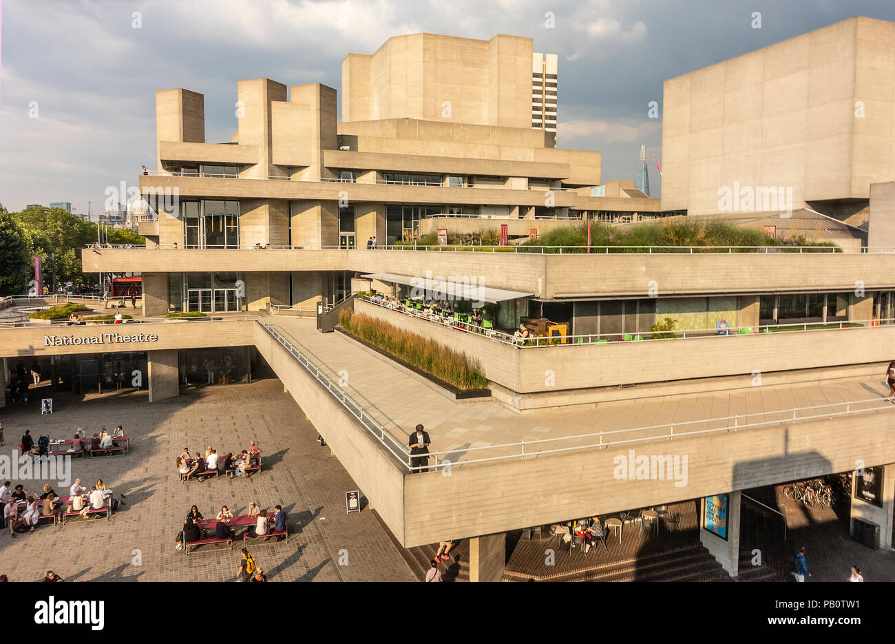 Tourists and locals enjoying a hot July evening outside the concrete Brutalist architecture of the National Theatre in London, UK Stock Photo