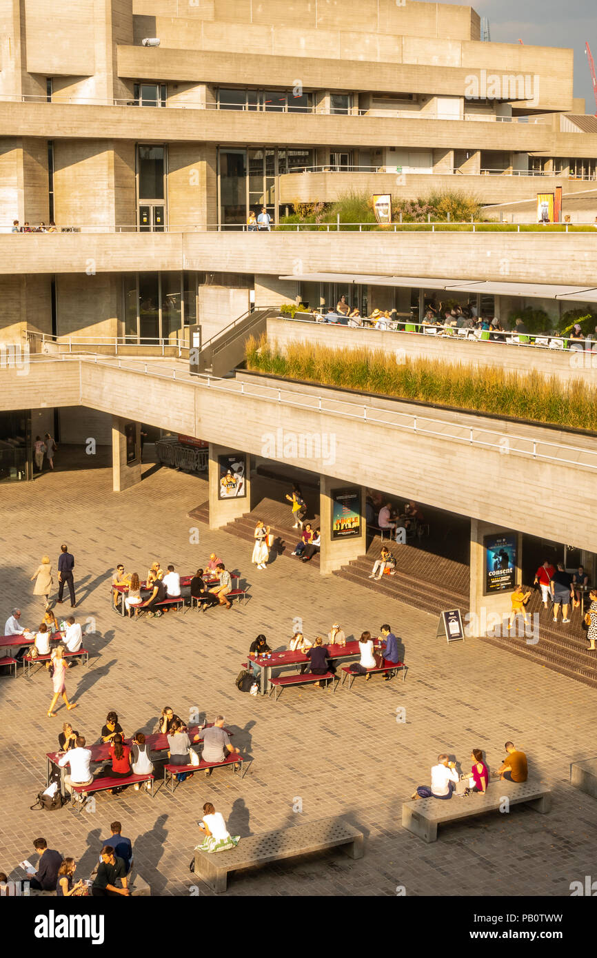 Tourists and locals enjoying a hot July evening outside the concrete Brutalist architecture of the National Theatre in London, UK Stock Photo