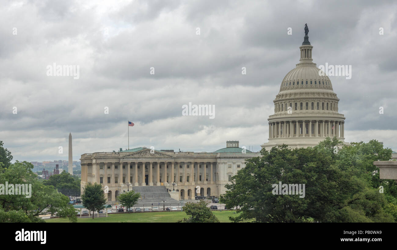 Rainy day view shows U.S. Capitol with Washington Monument, Smithsonian Castle, and Lincoln Memorialin background left. Stock Photo