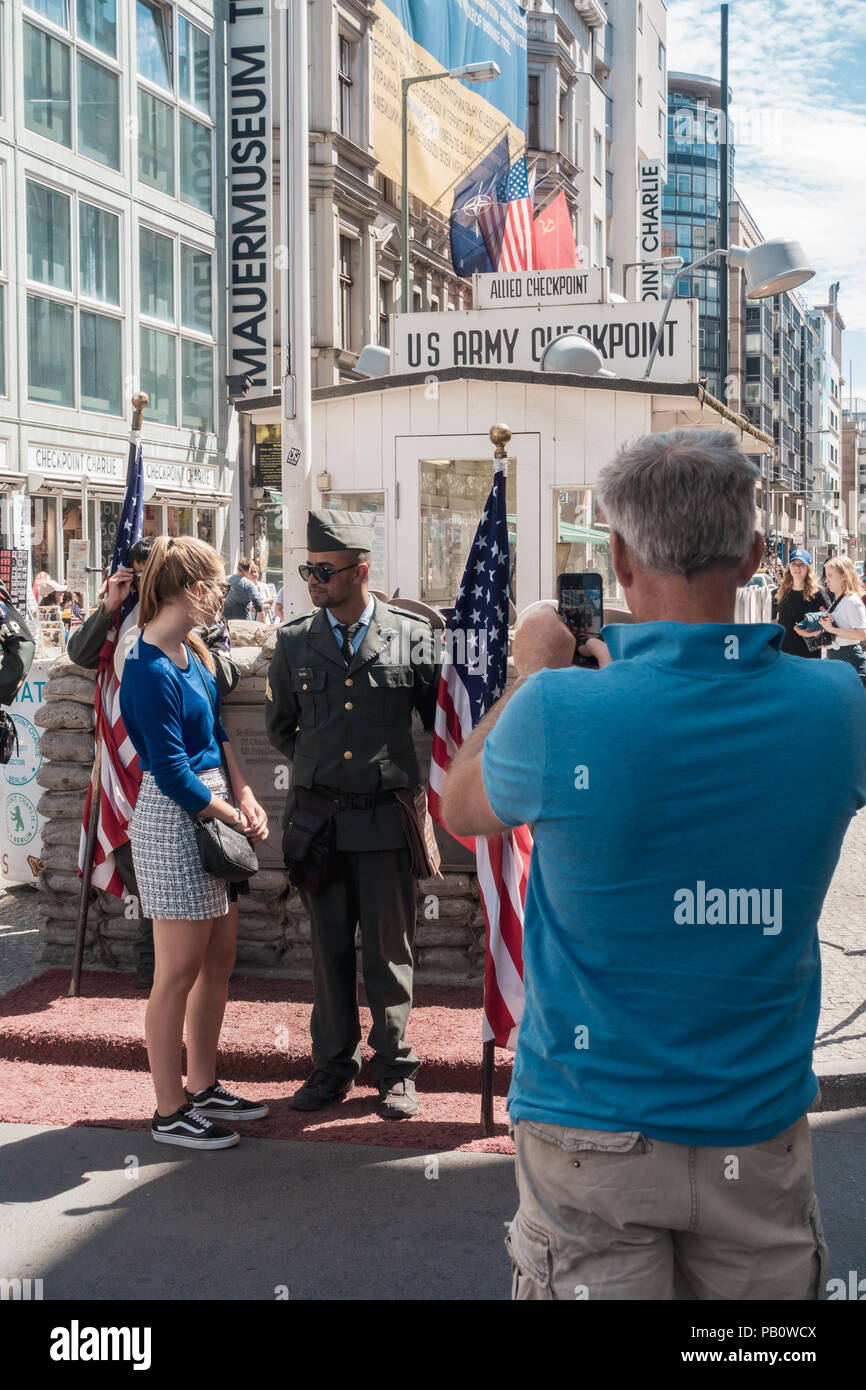 People visiting Checkpoint Charlie, making photographs with American soldiers Stock Photo