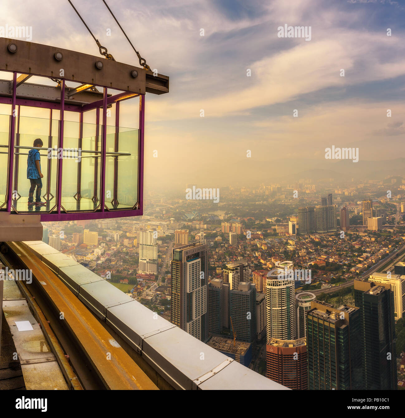 Boy on top of the Menara KL Tower with view of the Kuala Lumpur skyline Stock Photo
