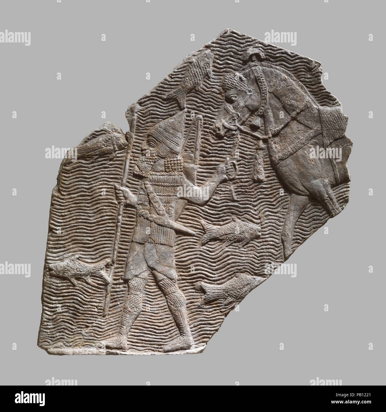Relief fragment: cavalryman leading his horse beside a stream. Culture: Assyrian. Dimensions: H. 23 3/8 x W. 25 15/16 in. (59.3 x 65.8 cm). Date: ca. 704-681 B.C..  This relief fragment dates to the time of the Assyrian king Sennacherib (r. 704-681 B.C.), and comes from the great Southwest Palace, called by Sennacherib the 'Palace Without Rival,' at Nineveh in northern Iraq. It shows an Assyrian soldier leading a horse beside a large river, and comes originally from a much larger scene depicting an Assyrian campaign that filled a room of the palace.  The soldier is equipped in typical Assyrian Stock Photo