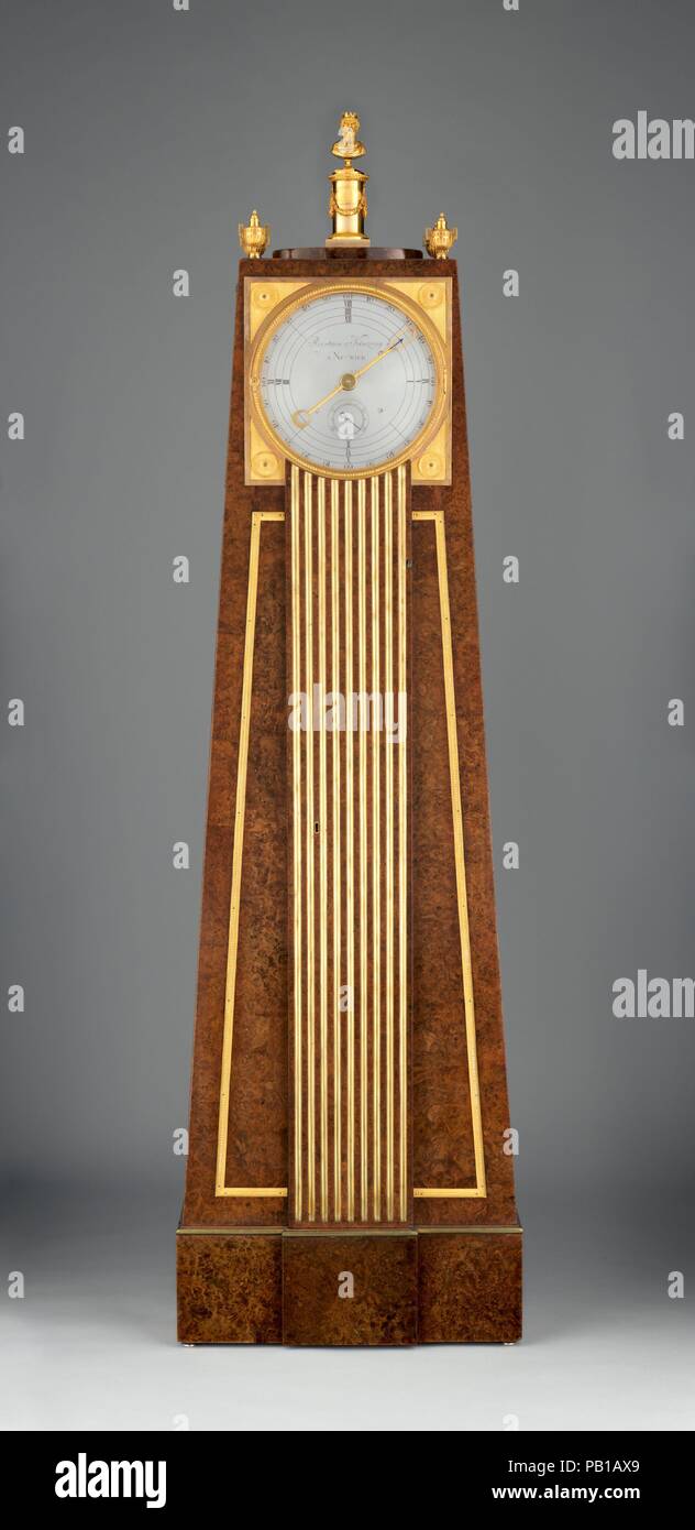 Obelisk clock with a Franklin movement. Artist: Clockmaker: Peter Kinzing (German, 1745-1816). Culture: German, Neuwied am Rhein. Dimensions: Overall: 75 × 21 1/8 × 7 5/8 in. (190.5 × 53.7 × 19.3 cm). Maker: Case maker: David Roentgen (German, Herrnhaag 1743-1807 Wiesbaden, master 1780). Date: ca. 1785-90.  The unusual obelisk shape of this case accommodates the swing of the pendulum and reflects the new taste for ancient Egyptian art, or 'Egyptomania,' in Europe at the time. The finial at the top of the clock is, fittingly, in the form of the double-faced head of Janus, the Roman god of begin Stock Photo