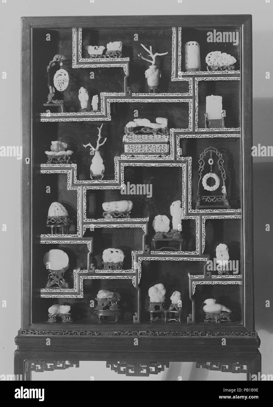 Vitrine Containing Twenty-Five Ornaments. Culture: China. Dimensions: a. Bird pendant: H. 2 in. (5.1 cm); W. 1 3/4 in. (4.4 cm)  b. Standing man: H. 2 in. (5.1 cm)  c. Standing man: H. 1 3/8 in. (3.5 cm)  d. Flower and leaf: H. 1 in. (2.5 cm); L. 1 1/8 in. (2.9 cm)  e. Floral buncH. H. 1 1/8 in. (2.9 cm); Diam. 1 1/2 in. (3.8 cm)  f. Vase with coral spray: H. 1 7/8 in. (4.8 cm), (vase)  g. Tree and bird: H. 3 5/8 in. (9.2 cm)  h. 2 small animals: H. 1 3/8 in. (3.5 cm); L. 2 1/4 in. (5.7 cm)  i. Leaf with lotus of amethyst quartz: H. 1 1/4 in. (3.2 cm)  j. Vase with coral spray:H. 4 3/4 in. (12 Stock Photo