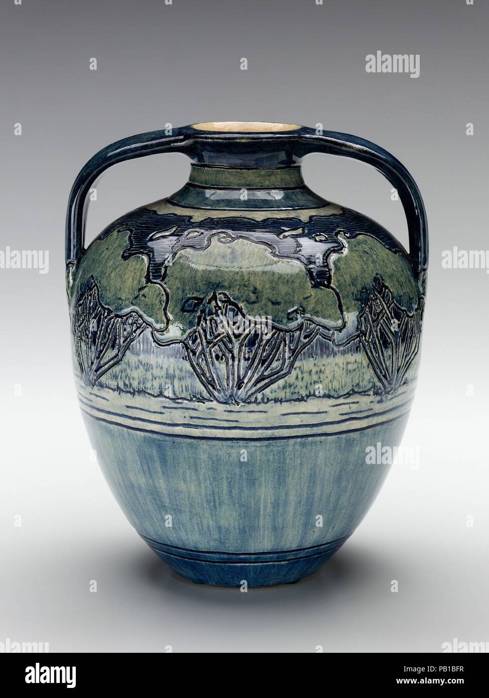 Vase. Culture: American. Dimensions: 8 7/8 x 7 1/8 in. (22.5 x 18.1 cm). Maker: Decorated by Mary Frances Baker (1879-1943). Manufacturer: Newcomb Pottery (1894-1940). Date: 1906.  Newcomb College of New Orleans is one of the earliest educational institutions to be associated with the Arts and Crafts Movement. It shared many of the movement's concerns, such as creating opportunities for women in the arts. It was the brainchild of Ellsworth Woodworth, who taught drawing and painting at Newcomb, and his brother William Woodward, a professor at Tulane University, who was especially interested in  Stock Photo