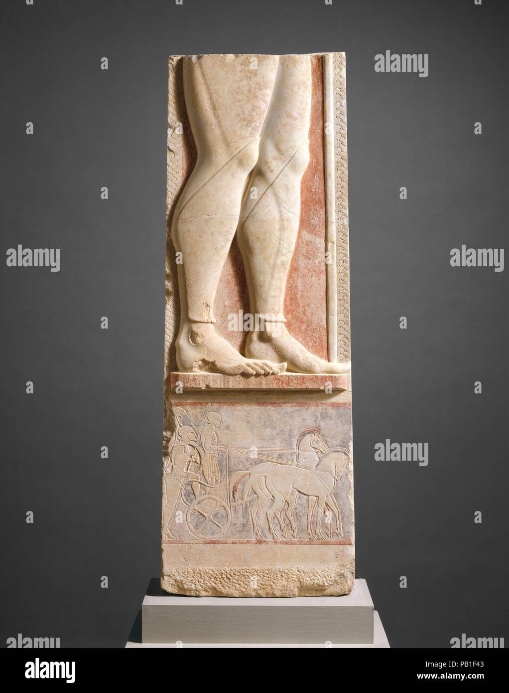 Fragment of the marble stele (grave marker) of a hoplite (foot soldier). Culture: Greek, Attic. Dimensions: Overall: 55 15/16 x 20 1/8 in. (142.1 x 51.1 cm). Date: ca. 525-515 B.C..  This grave marker commemorated a soldier, who was shown facing right, holding a spear. His lower legs, protected by greaves (shin guards), are preserved. The scene in the panel below shows a warrior mounting a quadriga (four-horse chariot), while his charioteer holds the reins. Such vehicles were used by the Mycenaean Greeks of the second millennium B.C. and are described by Homer in the Iliad and the Odyssey.  By Stock Photo