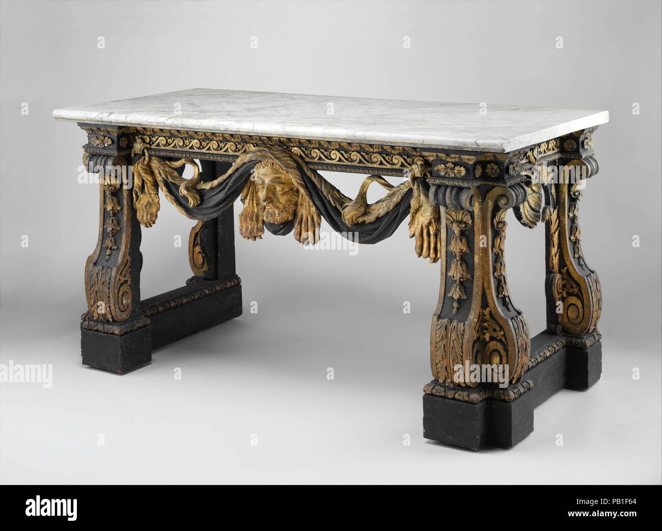 Table. Artist: After a design by Henry Flitcroft (British, Twiss Green, Cheshire 1697-1769 Hampstead). Culture: British. Dimensions: Overall: 35 3/4 × 68 1/4 × 34 1/2 in. (90.8 × 173.4 × 87.6 cm). Maker: Attributed to Matthias Lock (British, London ca. 1710-ca. 1765 London). Date: ca. 1740-45.  The front is carved with a mask of Hercules draped with the skin of the Nemean lion. The table corresponds to a drawing by Lock in the Victoria and Albert Museum. Several similar tables are known (Wentworth Woodhouse, Yorkshire; Shugborough Hall, Staffordshire; and Temple Newsam House, Leeds. Museum: Me Stock Photo