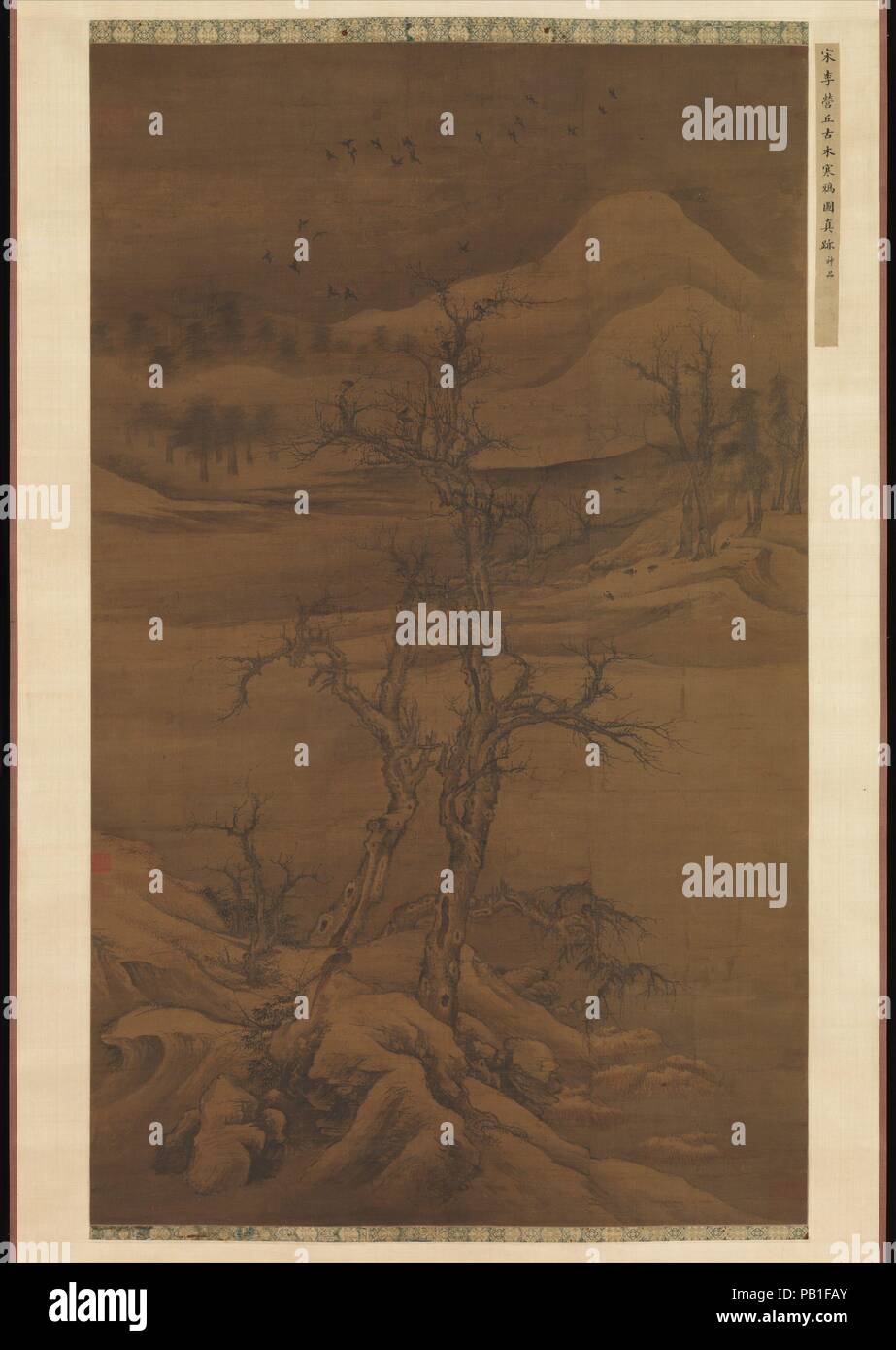 Crows in Old Trees. Artist: Luo Zhichuan (Chinese, active ca. 1300-30). Culture: China. Dimensions: Image: 52 x 31 5/8 in. (132.1 x 80.3 cm)  Overall with mounting: 9 ft. 6 1/4 in. x 38 3/4 in. (290.2 x 98.4 cm)  Overall with knobs: 9 ft. 6 1/4 in. x 42 1/2 in. (290.2 x 108 cm). Date: early 14th century.  This painting, by the southern artist Luo Zhichuan, demonstrates the renewed interest in the brush idioms of the Northern Song artists Li Cheng (919-967) and Guo Xi (ca. 1000-ca. 1090) that grew after the Mongol conquest forcefully reunified north and south China in 1279. Luo's painting may b Stock Photo