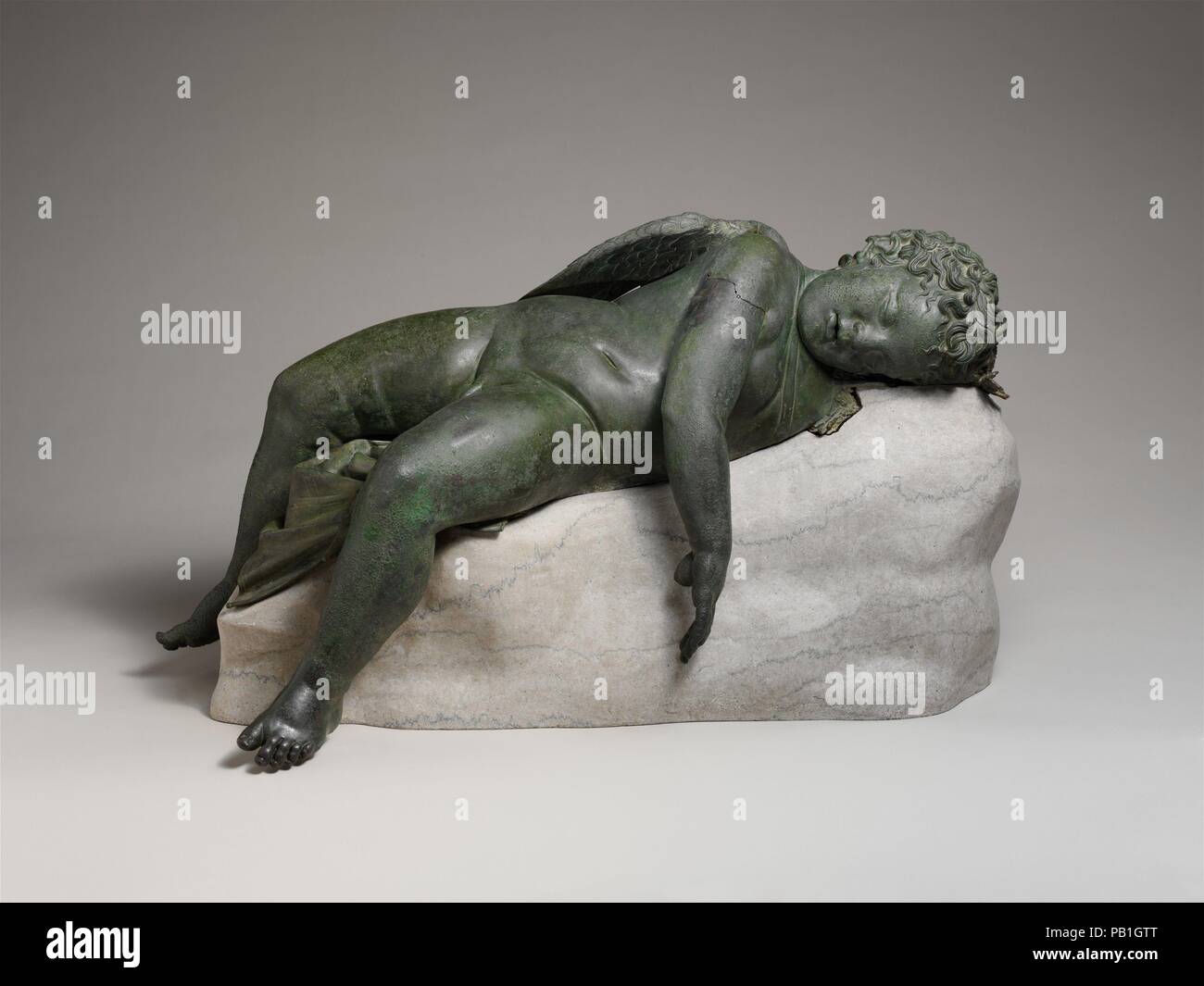 Bronze statue of Eros sleeping. Culture: Greek. Dimensions: 16 1/2 × 14 × 33 9/16 in., 275 lb. (41.9 × 35.6 × 85.2 cm, 124.7 kg)  Height (w/ base): 18 in. (45.7 cm). Date: 3rd-2nd century B.C..  The Hellenistic period introduced the accurate characterization of age. Young children enjoyed great favor, whether in mythological form, as baby Herakles or Eros, or in genre scenes, playing with each other or with pets. This Eros, god of love, has been brought down to earth and disarmed, a conception considerably different from that of the powerful, often cruel, and capricious being so often addresse Stock Photo