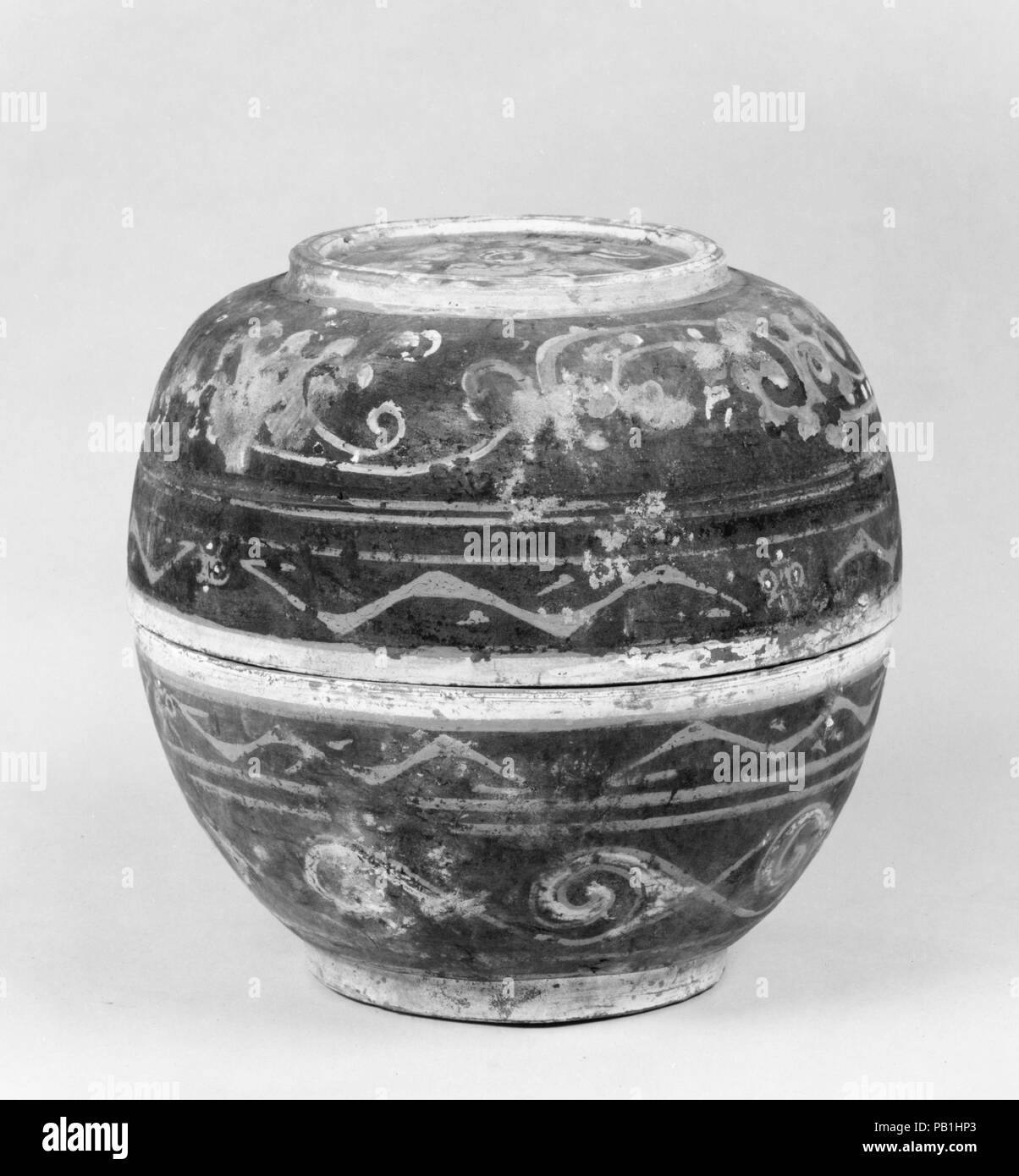 Covered Bowl (He). Culture: China. Dimensions: H. 6 7/8 in. (17.5 cm); Diam. 7 5/16 in. (18.5 cm).  Instead of being glazed, some tomb pottery was decorated with pigments applied after firing to mimic the form and decor of vessels made of more precious materials such as lacquer or bronze. Museum: Metropolitan Museum of Art, New York, USA. Stock Photo