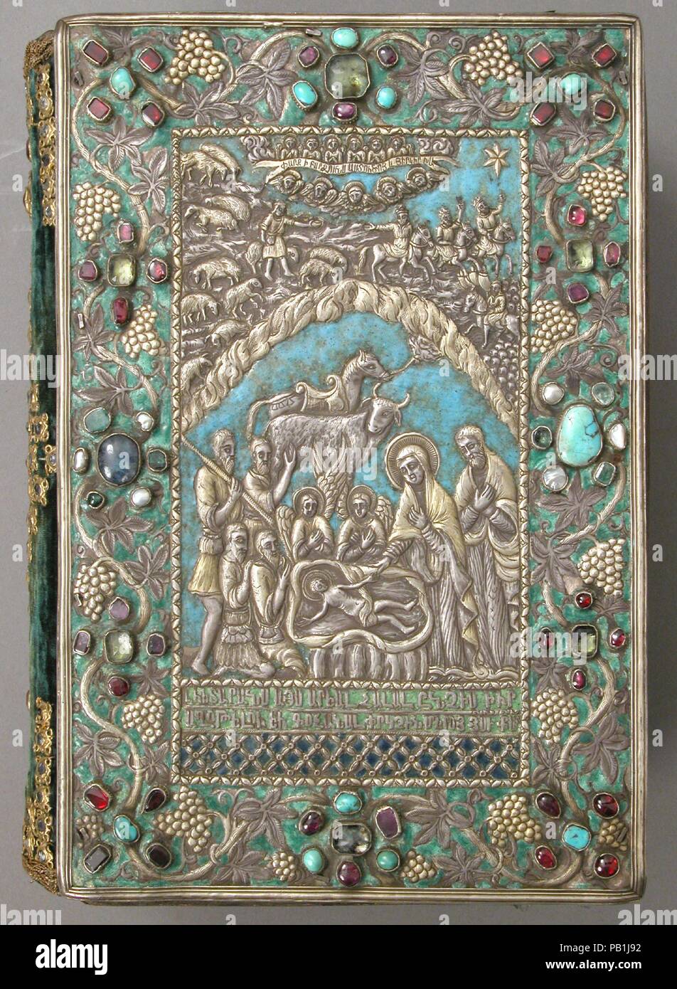 Gospel with Silver Cover. Dimensions: Pages: H. 10 in. (25.4 cm)   W. 6 3/4 in. (17.1 cm)  Binding: H. 10 1/4 in. (26 cm)   W. 7 3/8 in. (18.7 cm)  Approx. opening with cradle: H. 10 1/4 in. (26 cm)   W. 13 3/4 in. (34.9 cm)   D. 8 in. (20.3 cm). Date: 13th and 17th century.  These jeweled, enameled, and gilt-silver repoussé covers for a gospel are examples of the work produced in the late seventeenth-century silversmith workshop of Kayseri. Both front and back cover are signed, informing us that they were made in Kayseri in 1691 by Astuatsatur Shahamir. The central image on the front cover de Stock Photo