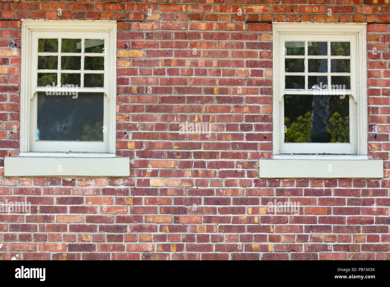 Vintage variegated brick wall and two windows Stock Photo
