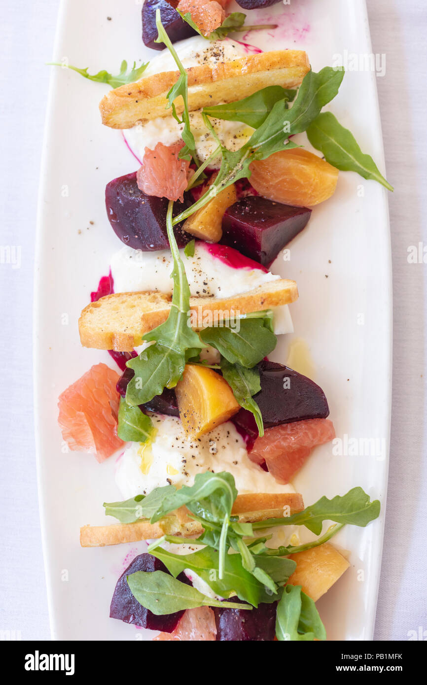 Gourment salad of red and golden beets with Burrata cheese and arugula Stock Photo