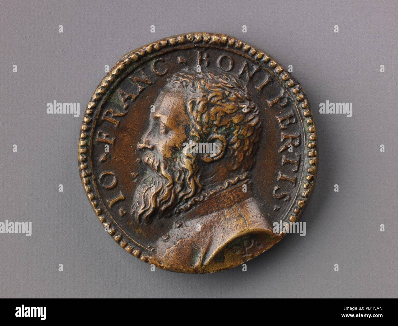 Medal:  Bust of Gianfrancesco Boniperti. Artist: Pastorino de Pastorini (Italian, Castelnuovo della Berardenga 1508-1592 Florence). Dimensions: Diam. 3.9 cm, wt. 26.02 g.. Date: model ca. 1550 (contemporary cast).  Pastorino de Pastorini was an Italian medallist, glass painter and die engraver. One of the most prolific Italian medallists, he produced around 200 medals. He was active in Ferrara, Bologna, Novellara, and Florence. On the obverse is a portrait of Gianfrancesco Boniperti (dates unknown); the reverse portrays an apple on a branch, which may have been his personal emblem. Museum: Met Stock Photo