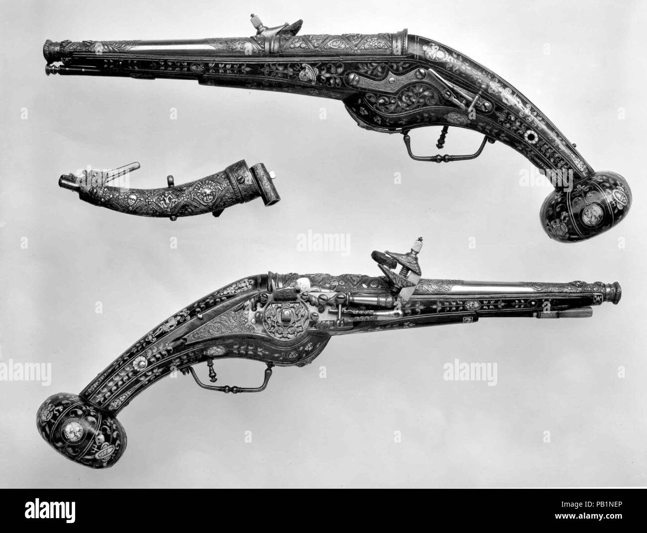 Pair of Wheellock Pistols with Matching Priming Flask/Spanner. Culture: French. Designer: Decoration on the stocks copied in part from engravings by Étienne Delaune (French, Orléans 1518/19-1583 Strasbourg). Dimensions: Cal. of each pistol, .44 in (11.18 mm); Wt. of 14.25.1433a: 4 lb. 2 oz. (1871 g); Wt. of 14.25.1433b: 4 lb. (1814 g); L. of each pistol, 20 1/8 in. (51.1 cm); L. of priming flask/spanner, 5 7/8 in. (14.91 cm). Date: ca. 1570-80.  These pistols are remarkable for the chiseled and gilt decoration of the barrels and locks, for the distinctive figural and floral inlay on the stocks Stock Photo