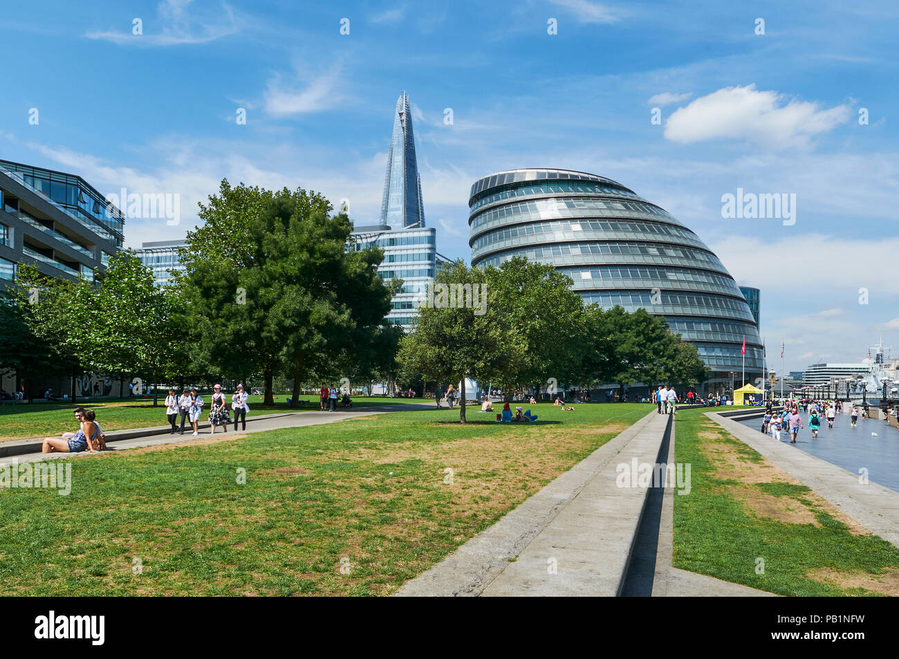 Lawns on the South Bank of the Thames, London UK, in summertime, looking towards City Hall and the Shard Stock Photo