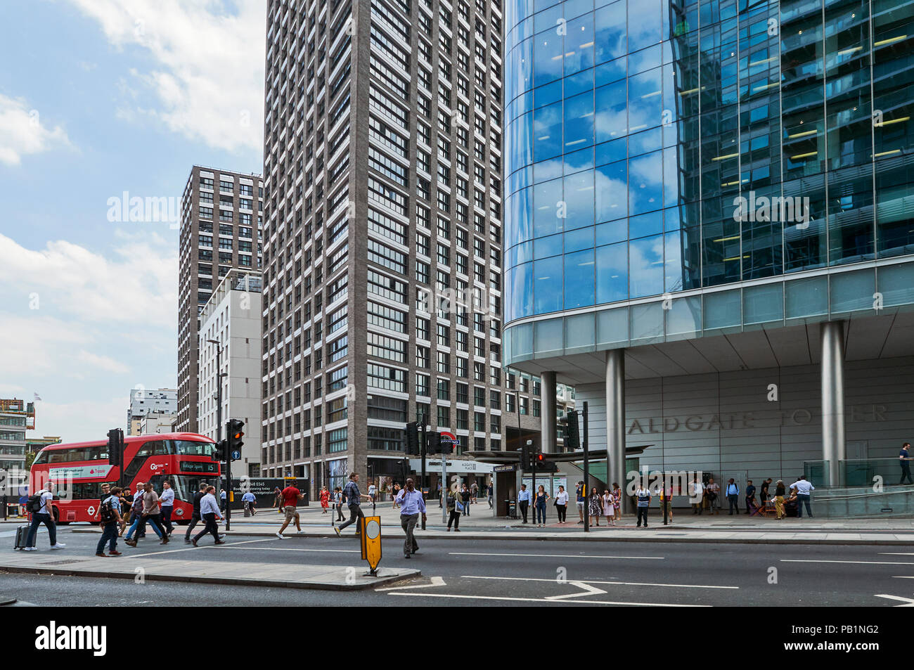 Gardiners Corner, Aldgate, London UK, with pedestrians, the new Aldgate East tube station entrance, and new apartment buildings Stock Photo