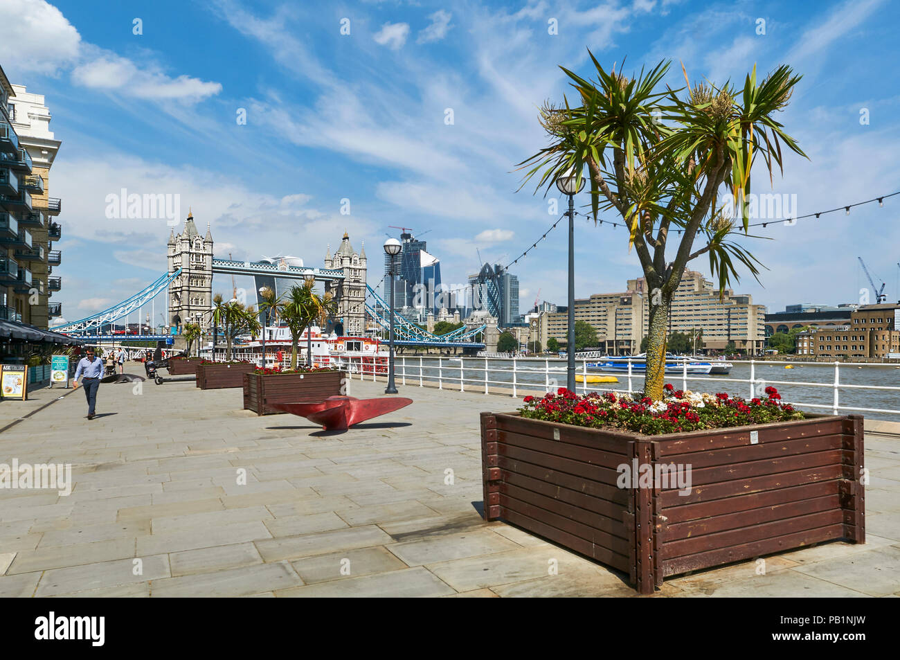 The newly pedestrianised riverside area behind Butlers Wharf buildings on the South Bank of the Thames, looking towards Tower Bridge, London UK Stock Photo
