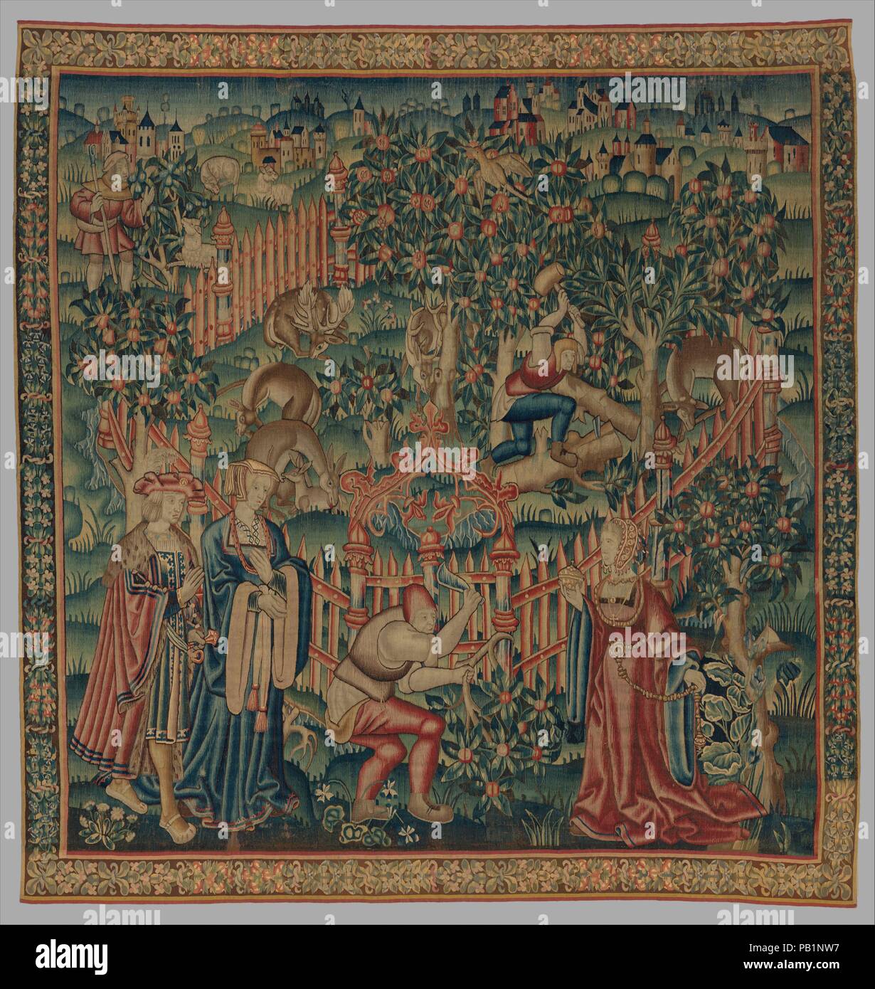 Woodcutters Working at a Deer Park (from the Hunting Parks Tapestries). Culture: South Netherlandish. Dimensions: Overall: 134 1/2 x 126 1/2in. (341.6 x 321.3cm). Date: ca. 1515-35.  In this tapestry, one from a set of four, woodsmen work in and around a hunting park filled with deer. Inside the enclosure, one woodsman stands upon a tree trunk, splitting it with a wedge and mallet. Deer nestle nearby, oblivious to his presence. Outside, near the gate, another woodsman prunes a branch while three noble figures hover nearby. The fine garments and jeweled accessories of the nobles distinguish the Stock Photo